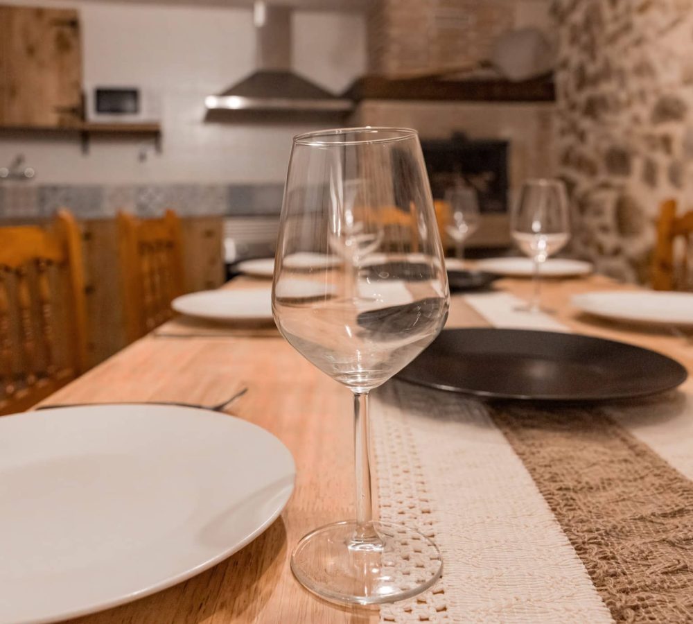 Mesa decorada con platos y copas de vino.