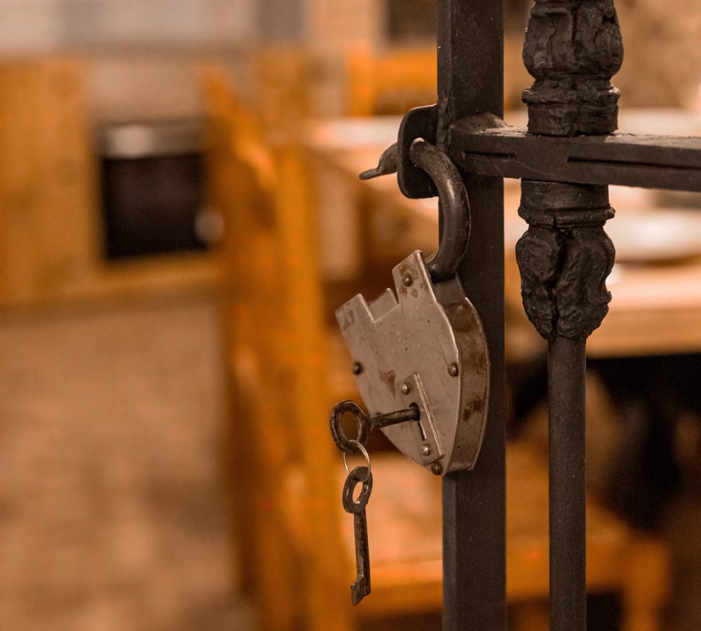 Candado antiguo con llave colgando en la puerta