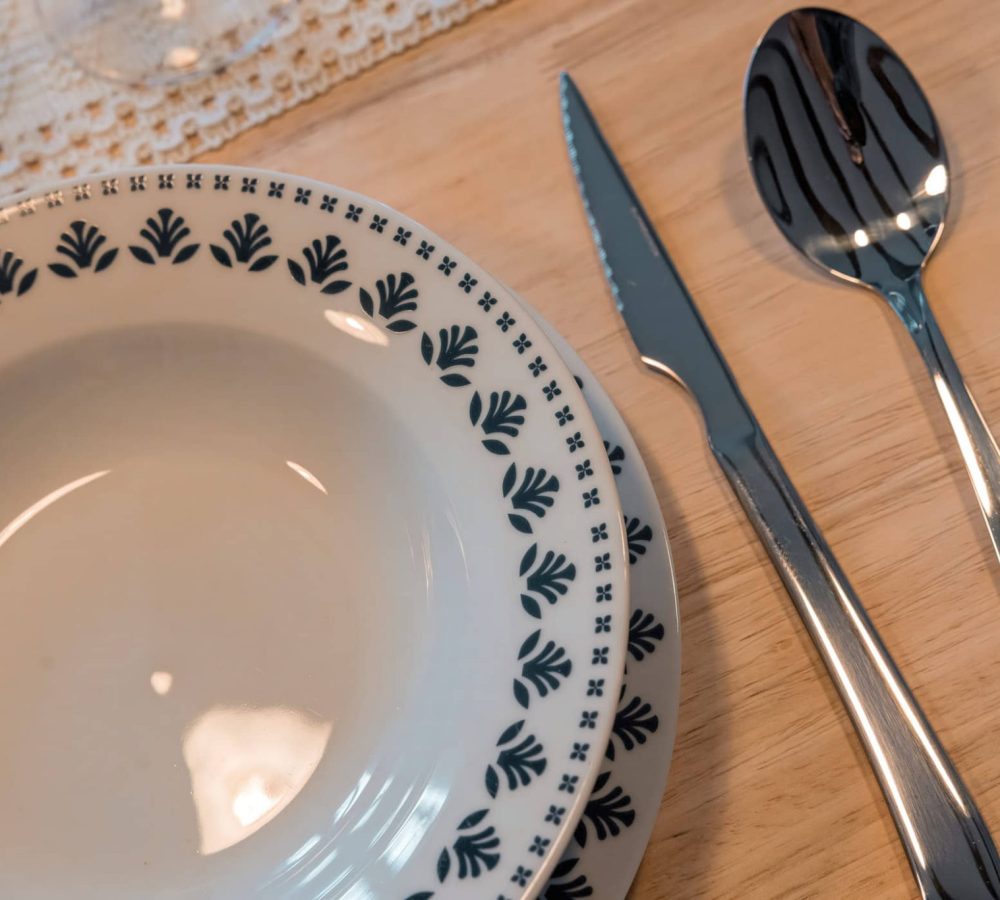 Plato y cubiertos sobre una mesa de madera.