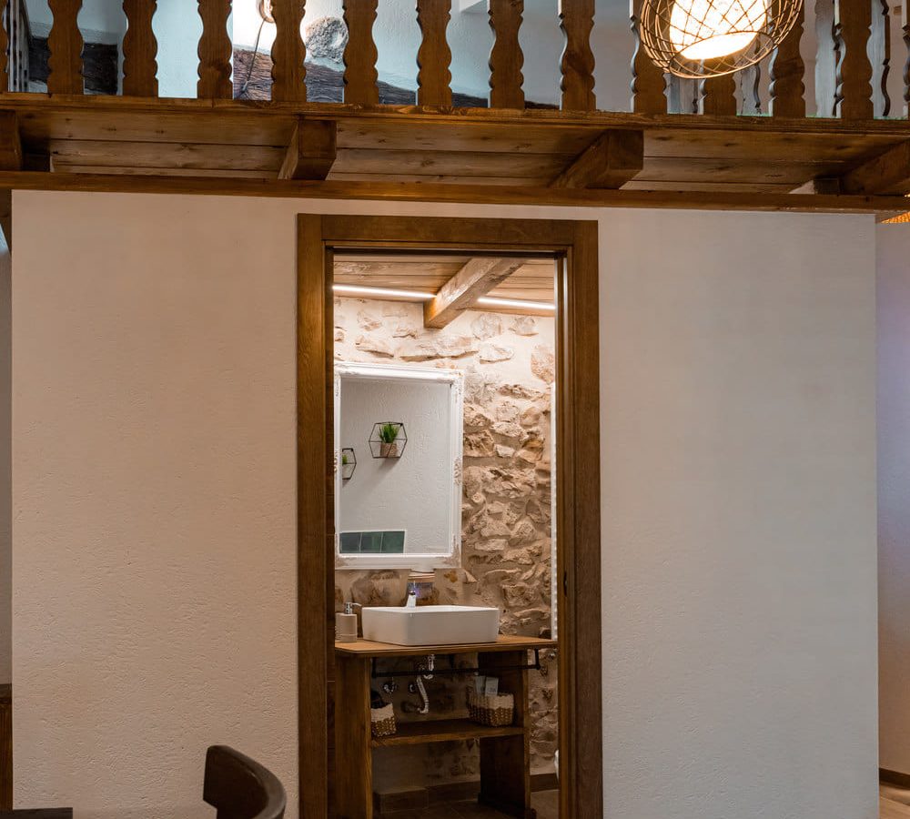 Interior de una casa con baño y detalles rústicos.