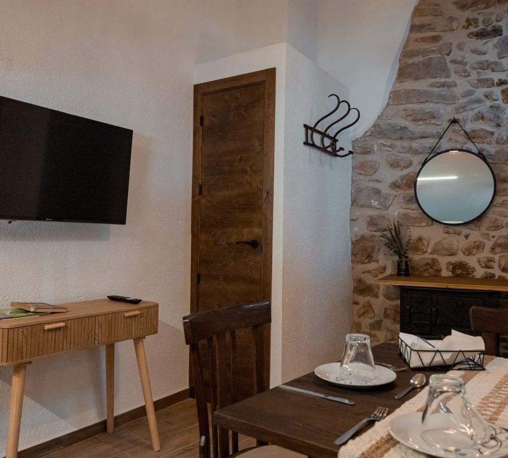 Sala de estar con televisor y mesa de comedor