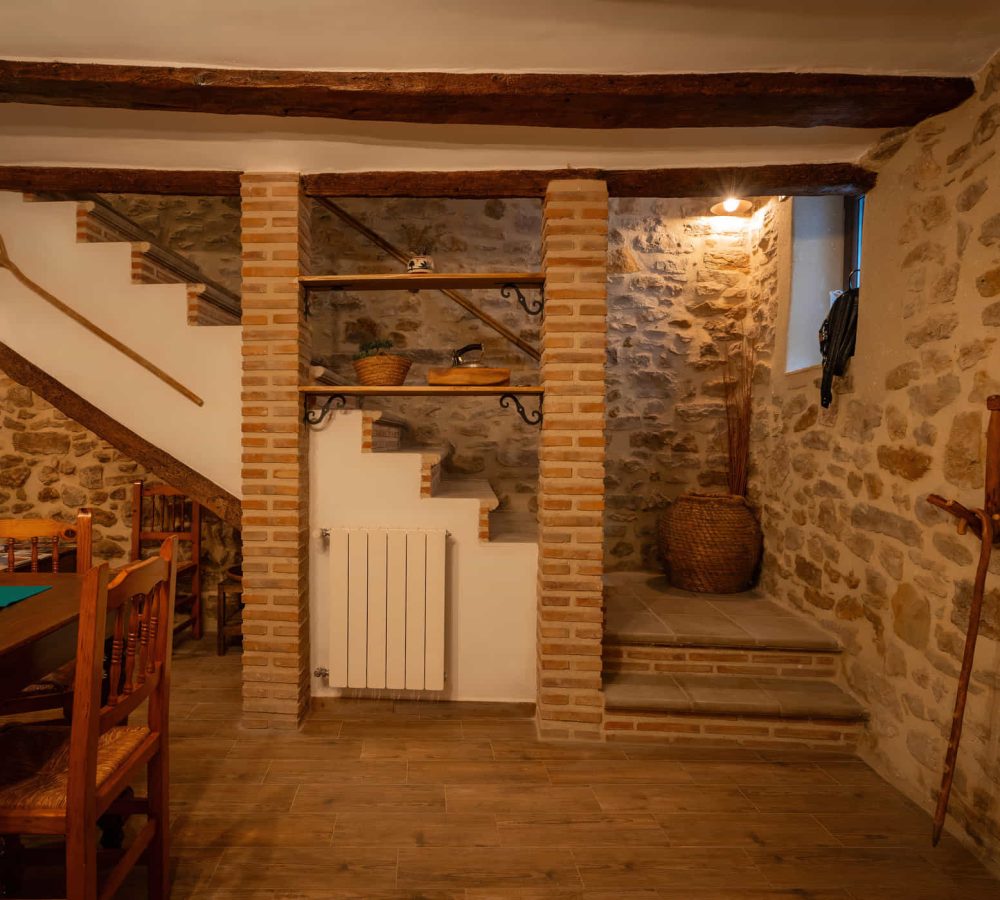 Interior rústico con escaleras y mesa de madera