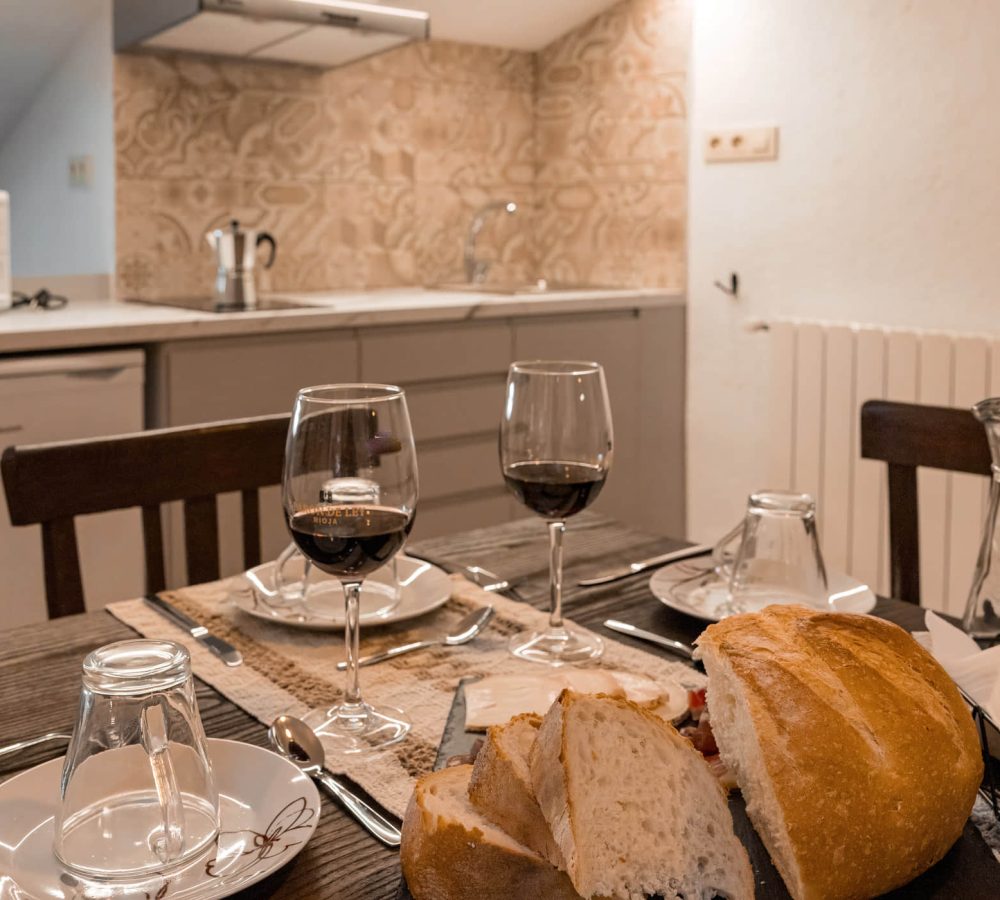 Mesa lista con pan y vino tinto.