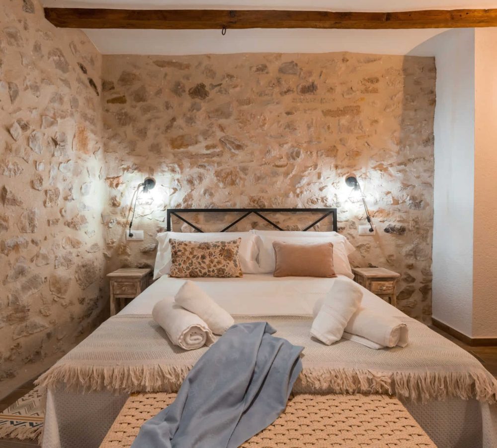 Habitación acogedora con paredes de piedra y cama.