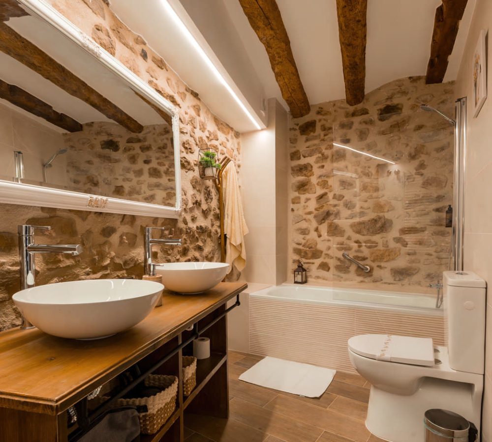 Baño moderno con detalles en piedra y madera.
