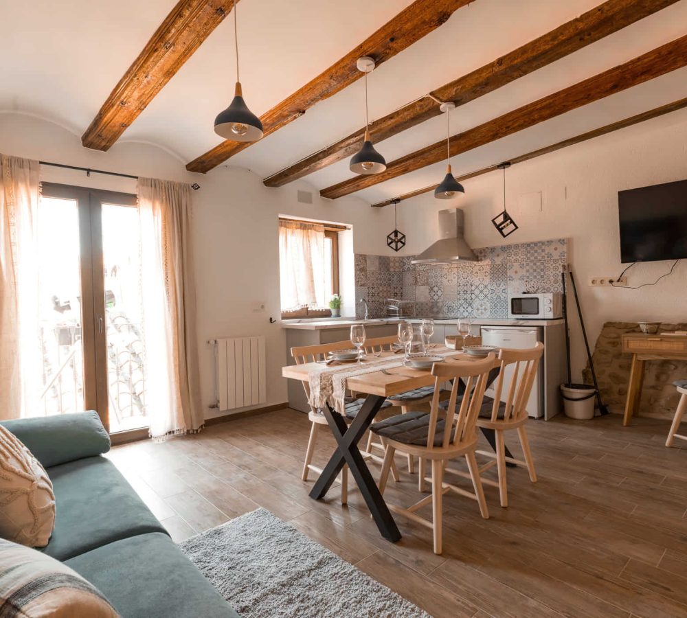 Salón y cocina luminosos con techos de madera