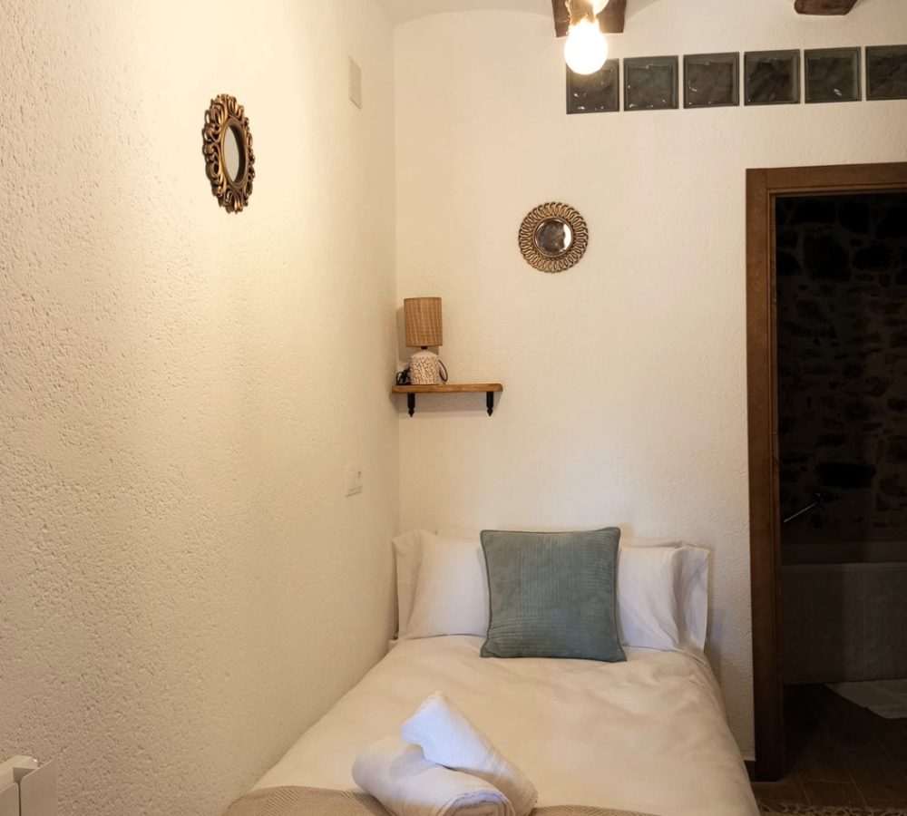 Habitación acogedora con cama y decoración sencilla.