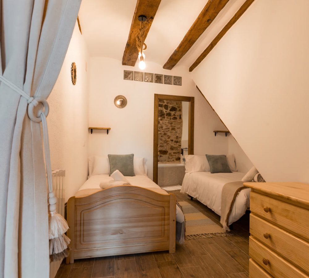 Habitación acogedora con camas individuales y madera