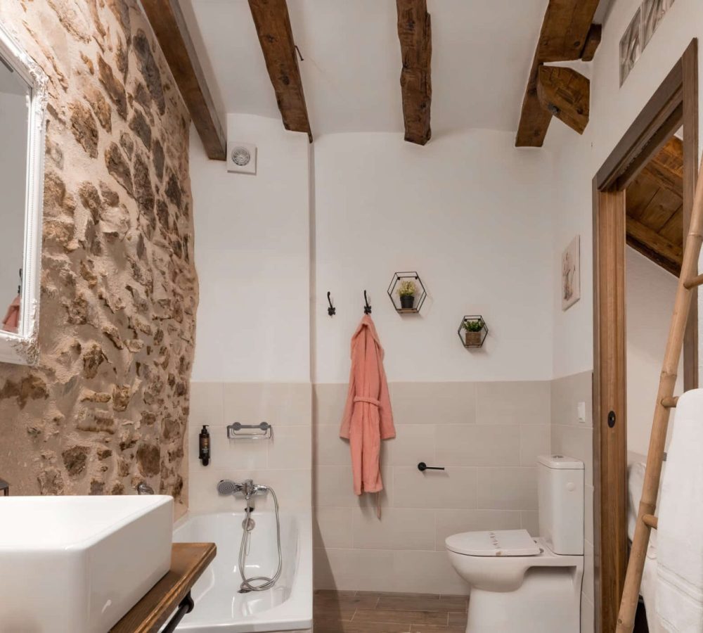 Baño moderno con detalles de piedra y madera.