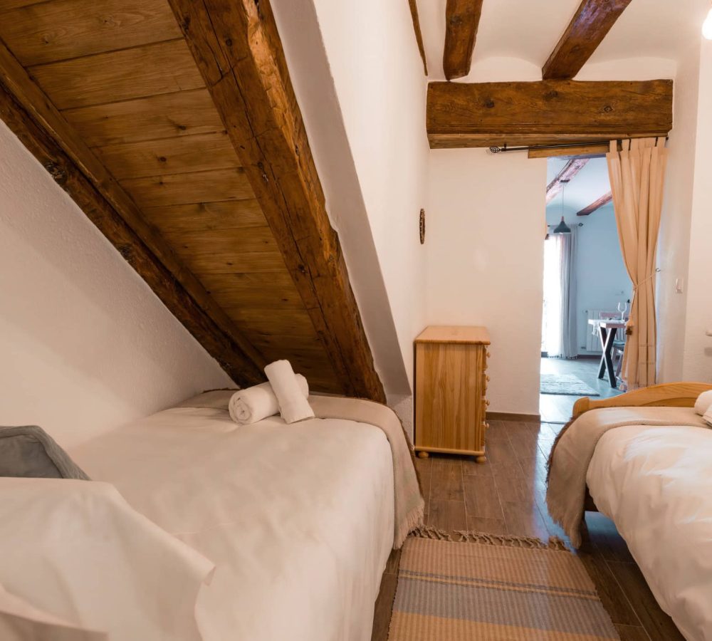 Habitación acogedora con techos inclinados y muebles de madera.