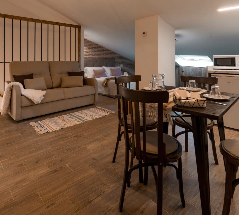 Salón acogedor con sofá y mesa de comedor.