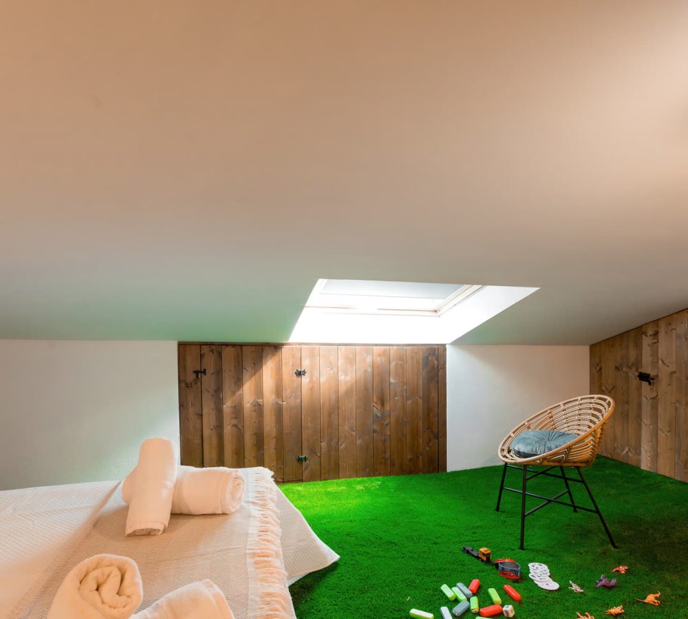 Ático con césped y muebles acogedores