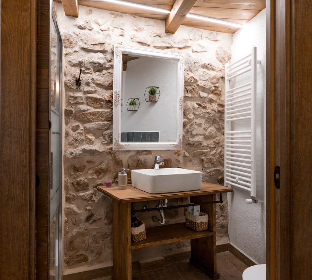 Baño con diseño rústico y lavabo moderno.