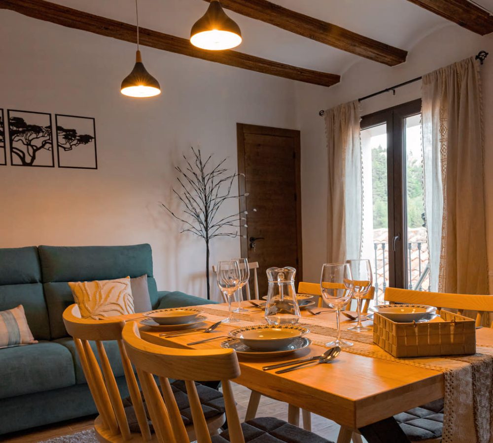 Comedor acogedor con mesa y luces colgantes.