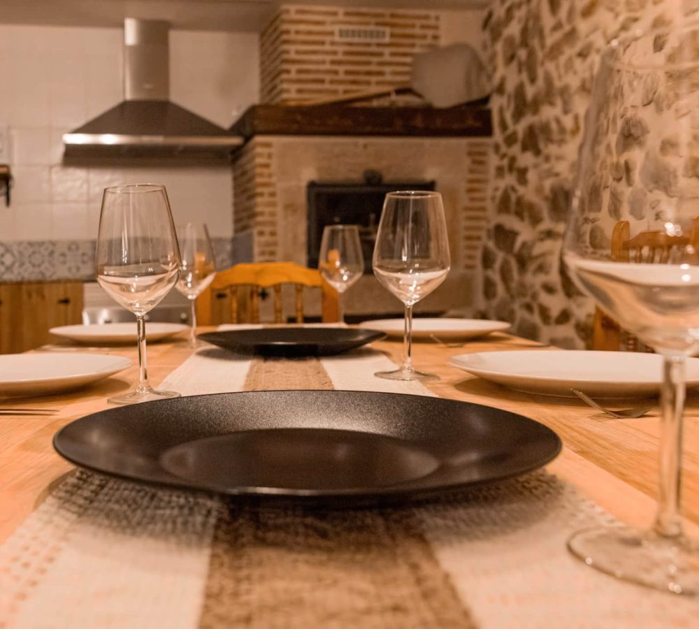 Mesa decorada con platos y copas vacías.