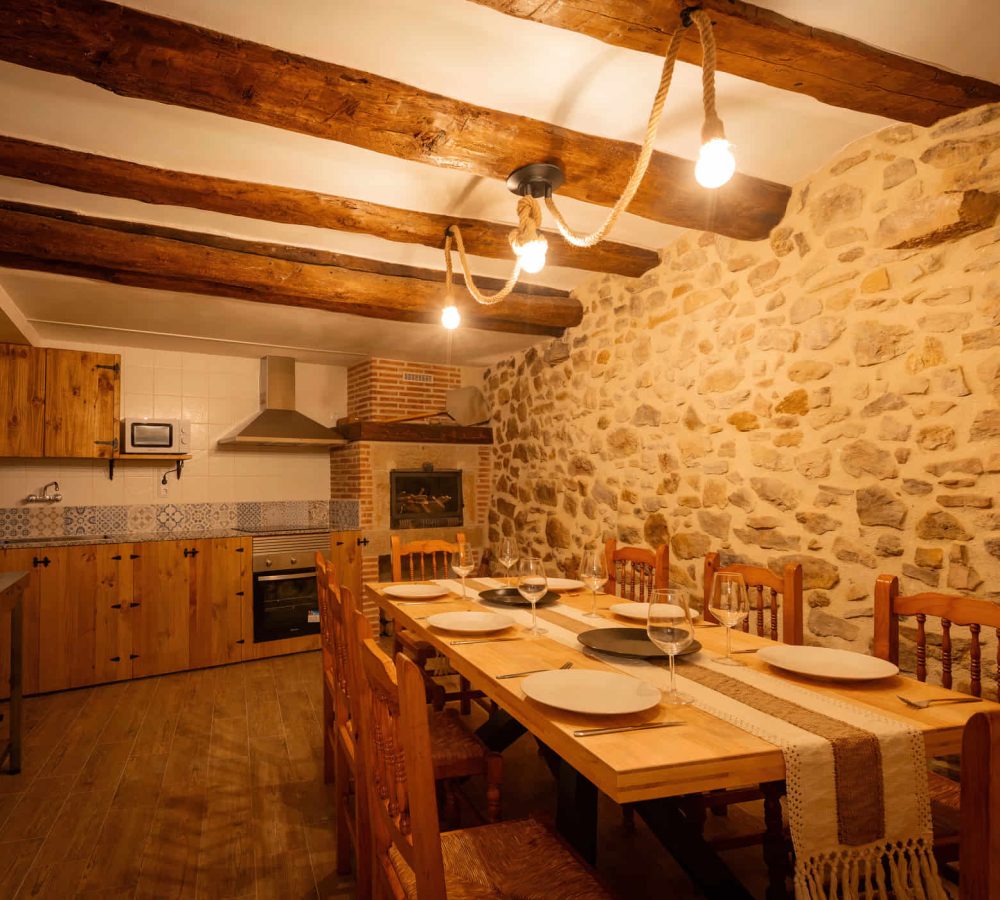 Cocina rústica con mesa y decoración acogedora.